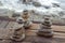 Three piles of Zen stones on a wooden floor at the Atlantic ocean sandy beach.