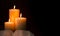 Three Pillar Candles Burning in a Dark Room with a Bible