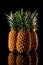 Three pineapple on a black reflective background