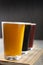 Three pint glasses of beer over wooden board. Golden, dark and red beer