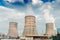 Three pipes at a nuclear power plant. Ukraine. Against the background of blue sky and cloudy sky.