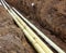 Three pipes in the trench in the ground diagonal