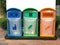 three plasstic trash recycle bin colour blue green orange with