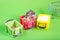 Three plastic containers on a green background filled with cereals from one steals buckwheat hamster