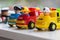 Three plastic toy cars representing Fire Brigade, Police Department and Garbage collection