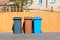 Three plastic waste bins outside a house