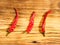 Three pods spice red chili pepper on wood background