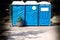 Three portable blue WC toilet cabins at construction site