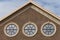 Three portal style windows on brick wall with cloudy blue sky