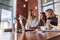 Three positive businesswomen working on laptop discussing joint business project