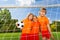 Three positive girls in uniforms with football