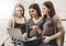 Three pregnant women are watching something interesting over internet