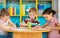 Three preschool children drawing at daycare