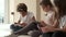 Three pretty multi ethnic african, caucasian and korean little kids sit indoors using wireless gadgets. Overuse of modern tech