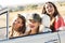 Three pretty young women driving on road trip on beautiful summe