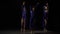 Three professional ballerinas are dancing in twilight at studio.