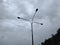 Three-pronged lamppost against a cloudy sky background