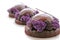 Three purple chocolate desserts with shiny mirror glaze and fresh blackberries