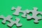 Three puzzle pieces in wood on green background