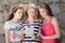 Three puzzled teenage girls friends looking on tablet pc on summer day