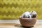 Three Quail Eggs In A Small Wooden Bowl on a Kitchen Counter Top