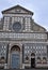 Three quarters, with two doors, of the beautiful facade covered in white marble with black marble outline, of the church of Santa