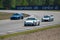 Three race sports car drives along a racing circuit.