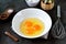 Three raw eggs in a bowl for cooking scrambled eggs.