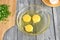 Three raw eggs are broken into a deep glass dish for making an omelet