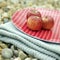 Three red apples on a folded picnic blanket. Conceptual image