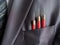 Three red darts in businessman suit pocket