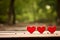 Three Red Hearts on Wooden Surface in Nature