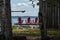 Three red muskoka chairs on a dock looking out into the lake