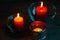 Three red paraffin candles in decorative glass candlesticks