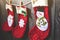 Three red stocking with fir-tree branches and christmas decorations on wooden table