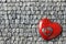 Three red Valentines day hearts on an background of old grey cobblestone bricks