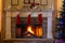 Three red and white Christmas stockings hung by the stone fireplace to decorate for the holidays