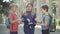 Three relaxed cheerful children standing on school yard and playing rock-paper-scissors. Portrait of joyful carefree