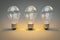 three retro style lightbulbs with glowing filament standing in a row on infinite colorful background creativity design concept