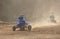 Three riders on a quad bike in the dust race