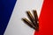 Three rifle cartridges on the flag of France. Close-up, copy space