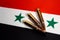 Three rifle cartridges on the flag of Syria. Close-up, copy space