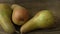 Three ripe juicy pears on a dark wooden table