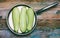 Three ripe light green zucchini with pan on wooden retro background, top view