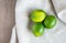 Three ripe limes on a linen cloth with copy space