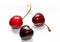 Three ripe red cherries close up on a white background. A group of delicious and beautiful cherries