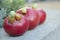 Three ripe red organic tomatoes on a concrete surface, selective focus. Unusual appearance concept