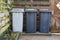 Three rolling trash cans in a dutch garden