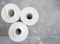 Three rolls of new white blank Wallpaper on blurry gray tile floor.Home,room renovation,house construction,wallpapering