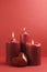 Three romantic red lit candles, vertical with copy space.